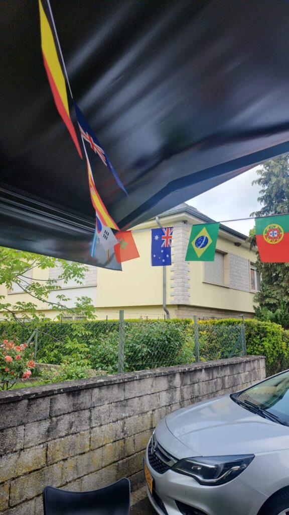 terrasse de café les Bons amis decoré avec les drapeaux des equipes qualifiées pour la coupe du monde 2026 