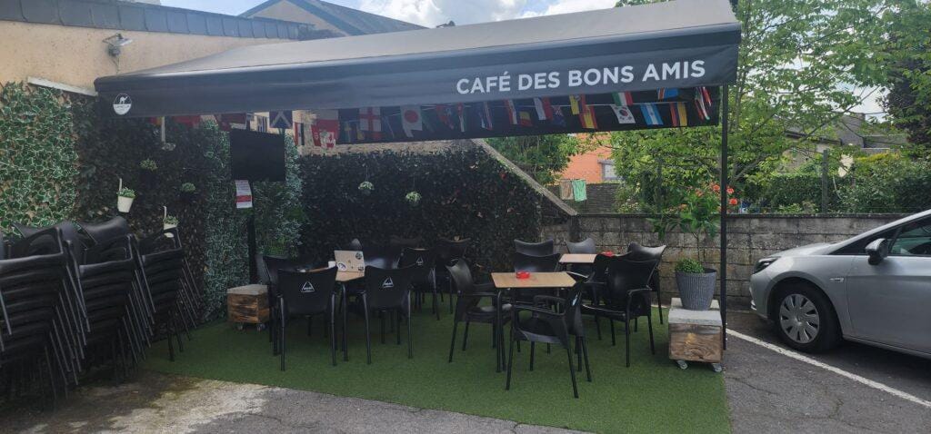 terrasse de café les Bons amis decoré avec les drapeaux des equipes qualifiées pour la coupe du monde 2026 